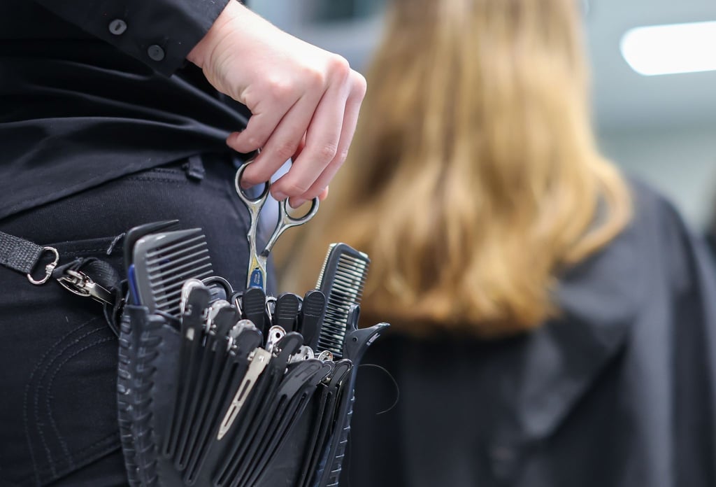 Eine Friseurmeisterin schneidet in einem Salon einer Kundin die Haare.