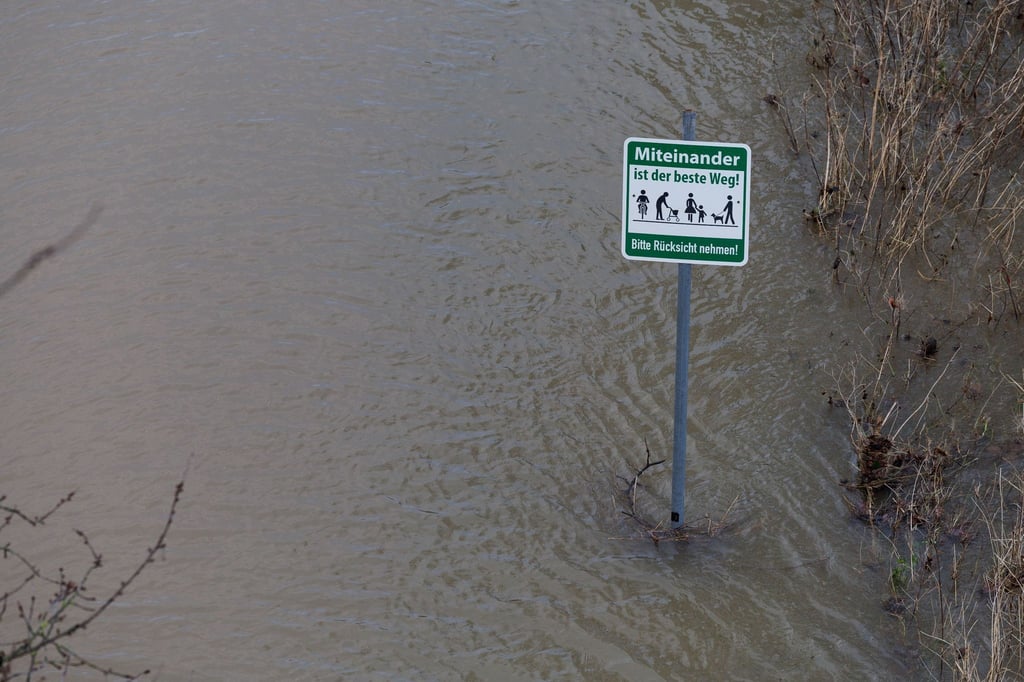 Ein Schild ist nahe der Hochwasser führenden Weser zu sehen.