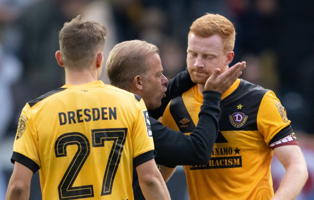Dynamo Trainer Markus Anfang (M) umarmt nach dem Spiel Paul Will (r).