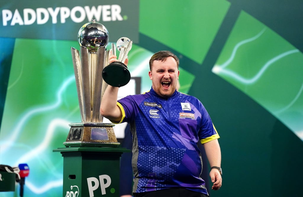 Luke Littler jubelt mit dem Pokal für den zweiten Platz nach seiner Niederlage im Finale.