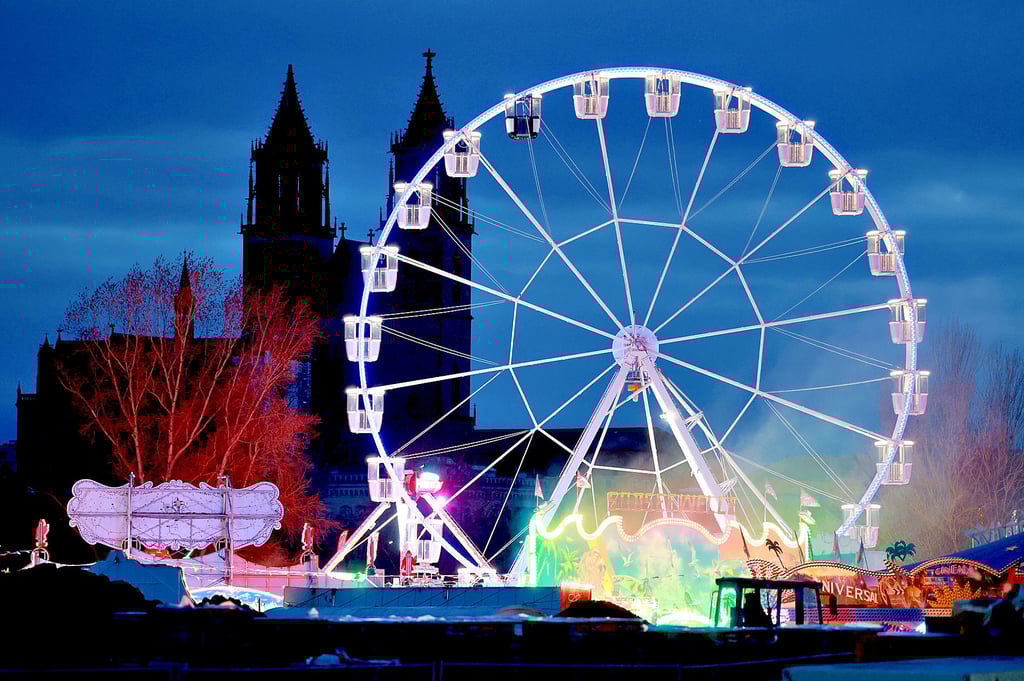 Ein Riesenrad dreht sich vor der Silhouette des Magdeburger Doms.