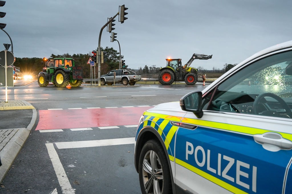 Traktoren von Bauern blockieren eine Zufahrt zur Autobahn.