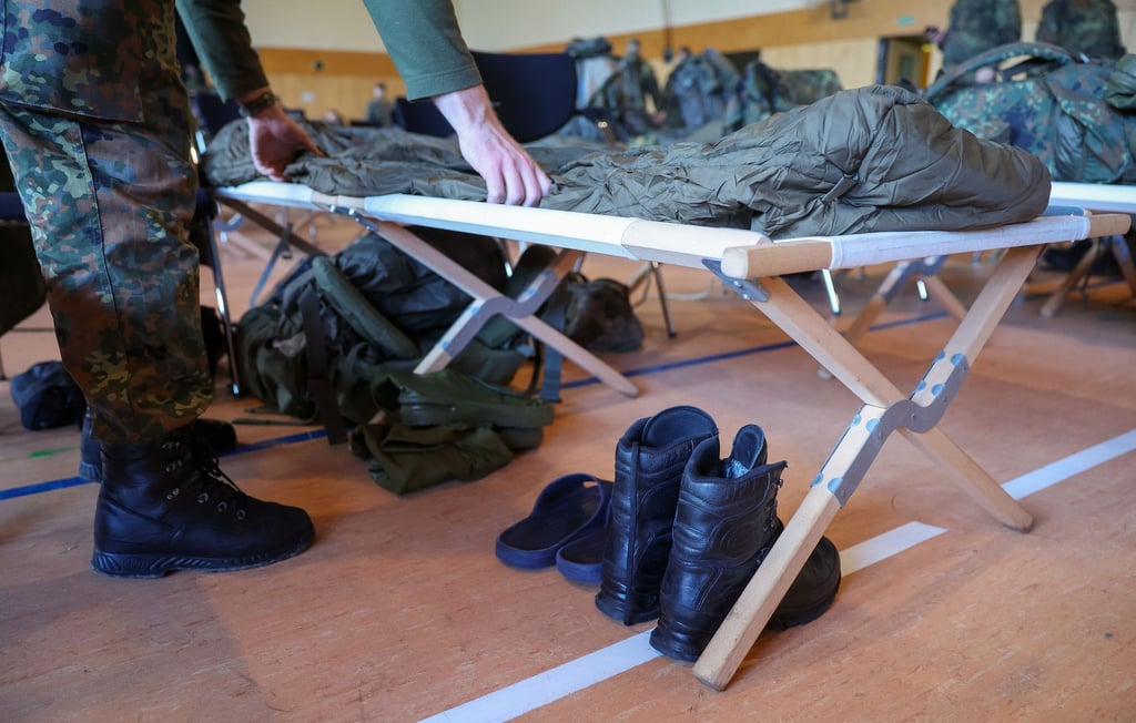 Ein Soldat der Bundeswehr bereitet sein Feldbett vor.