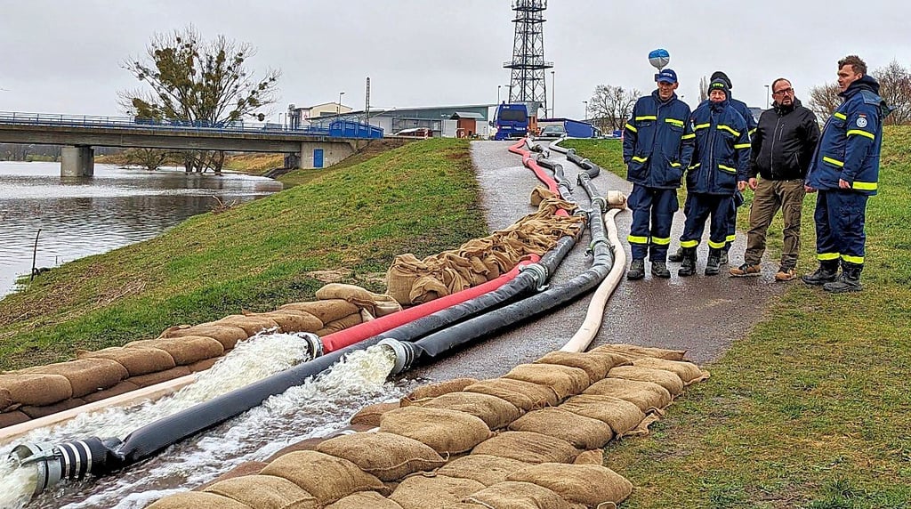 Bürgermeister Kay Gericke im Gespräch mit den Einsatzkräften des THW-Ortsverbandes Oschersleben, die am Siel in Heyrothsberge das Wasser in den Umflutkanal überpumpen.