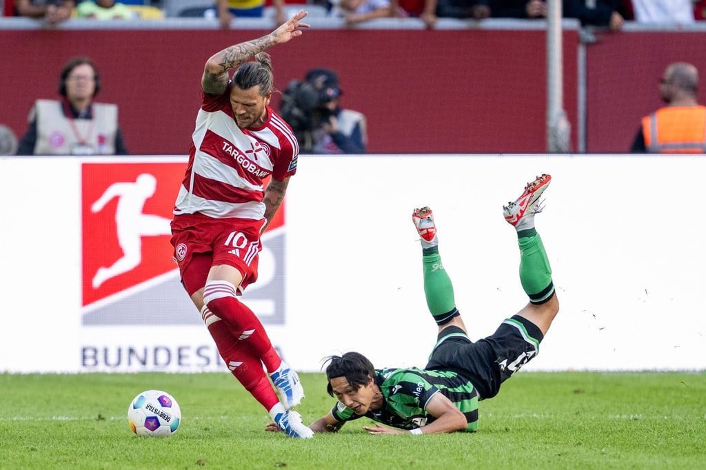 Düsseldorfs Daniel Ginczek (l.) und Hannovers Sei Muroya kämpfen um den Ball.