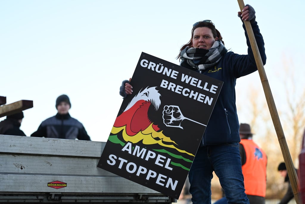 "Grüne Welle brechen, Ampel stoppen" steht auf einem Plakat der Bewegung "Land schafft Verbindung" (LSV) das Melanie Neelen, Landwirtin aus der Region, in der Hand hält.