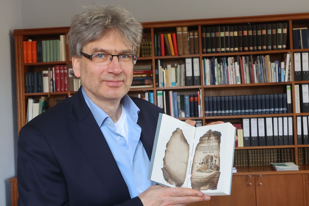 Reinhard Laube, Direktor der Herzogin Anna Amalia Bibliothek, zeigt ein wieder hergestelltes Buch nach dem Brand von 2004.