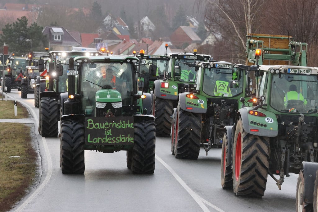 Landwirte fahren mit ihren Traktoren über die Bundesstraße 7.