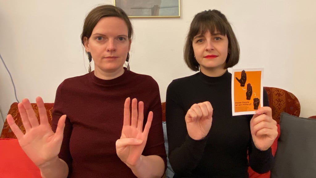 Die Magdeburgerinnen Kristin Plumbohn (links) vom „präsent"-Magazin und Sally Bo Hattar haben die Spendenkampagne "a safe place" für das Frauenhaus ins Leben gerufen. Beide Frauen zeigen das Hilfezeichen, auch „Handzeichen häusliche Gewalt“ genannt, das Menschen in der Öffentlichkeit zeigen können, wenn sie sich bedroht fühlen und Hilfe benötigen.