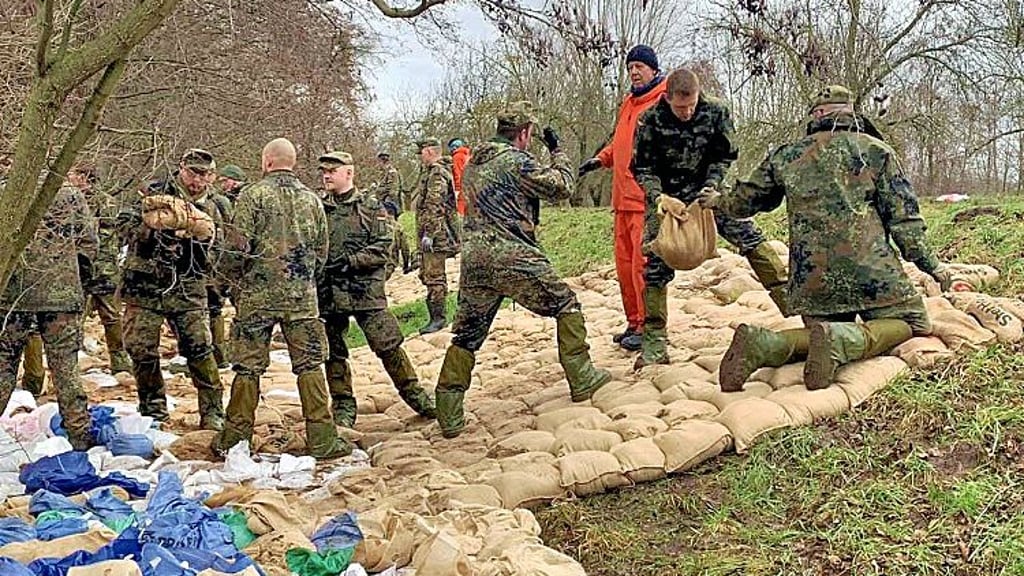 Bundeswehrsoldaten arbeiten am Deich bei Oberröblingen unter Anleitung des Technischen Hilfswerks (THW).