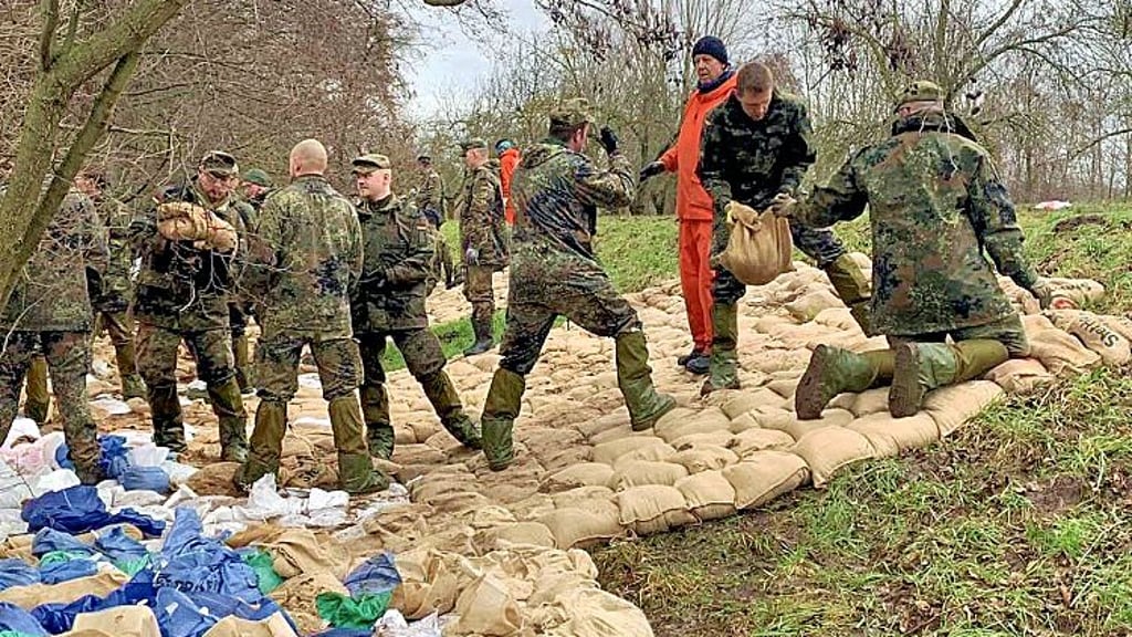 Bundeswehrsoldaten arbeiten am Deich bei Oberröblingen unter Anleitung des Technischen Hilfswerks (THW).