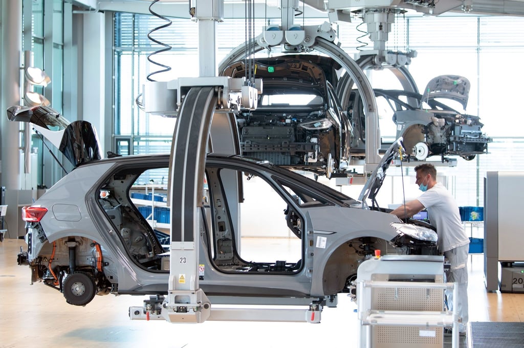 Ein Mitarbeiter von Volkswagen arbeitet an einem VW ID.3 in der Endmontage.
