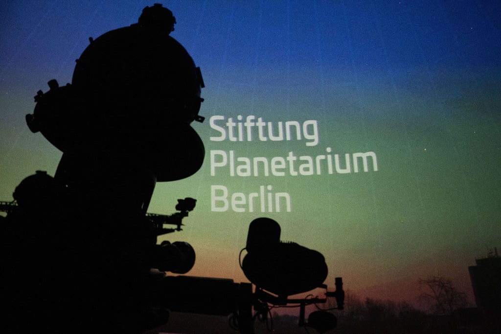 Ein Sternenprojektor vor einer Wand mit dem Schriftzug "Stiftung Planetarium Berlin".