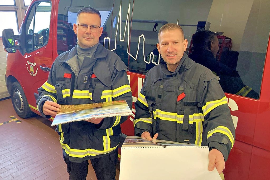 Jens Wiedemann (links) und Marc Sommer mit dem Kalender, der erstmals mit Bildern der Burger Feuerwehr erstellt wurde.