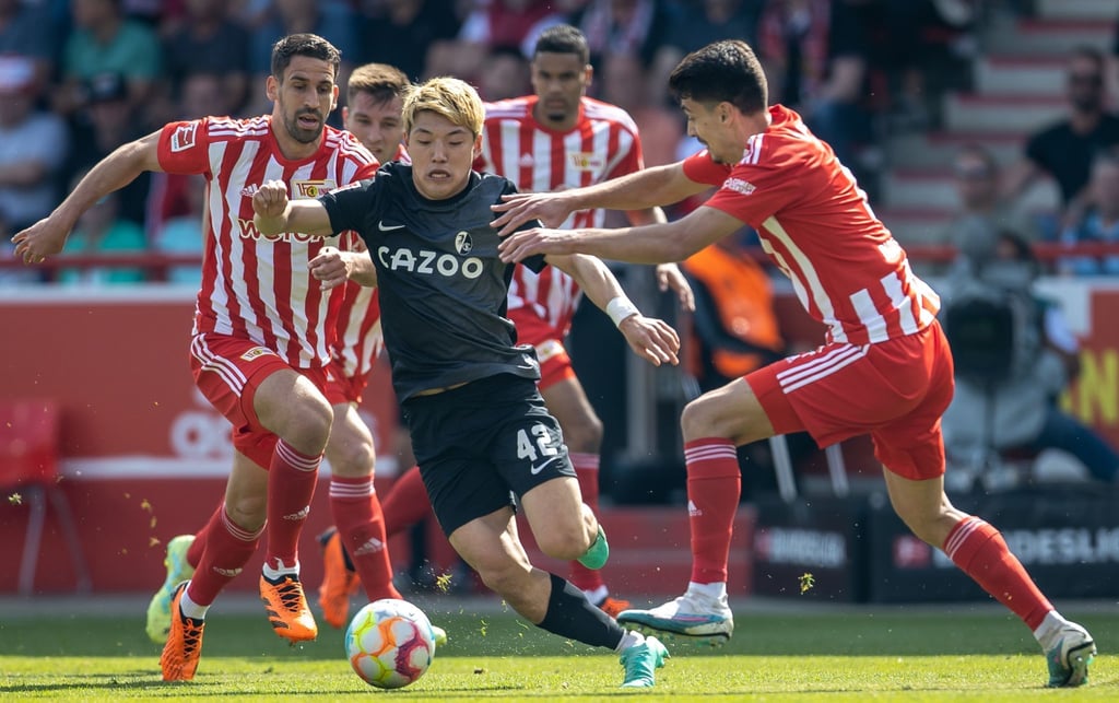 Ritsu Doan von SC Freiburg kämpft gegen Berlins Rani Khedira (l) und Diogo Leite (r) um den Ball.