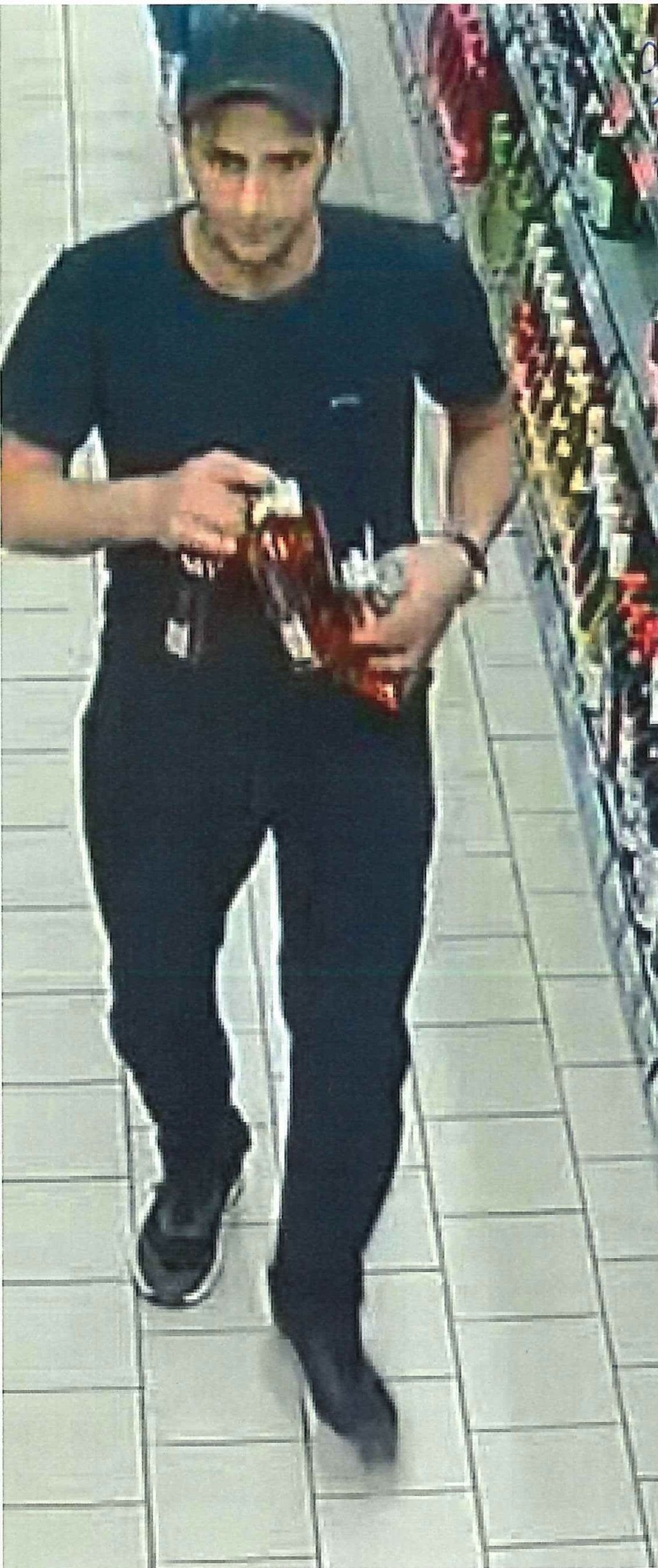 Einer der Täter mit den alkohlischen Getränken in der Hand.