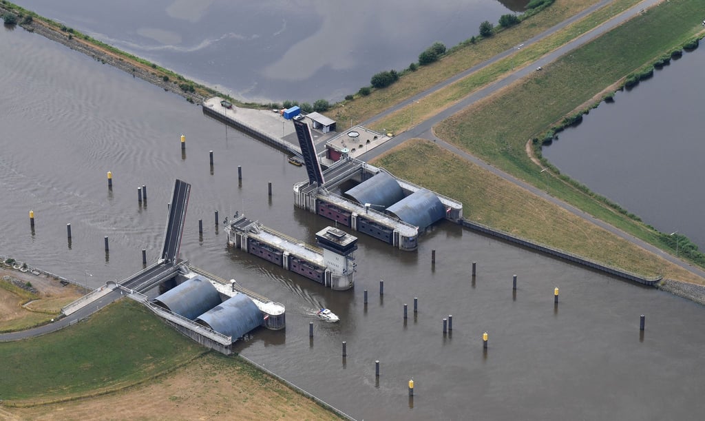 Ein Sportboot fährt durch das Huntesperrwerk in Elsfleth.