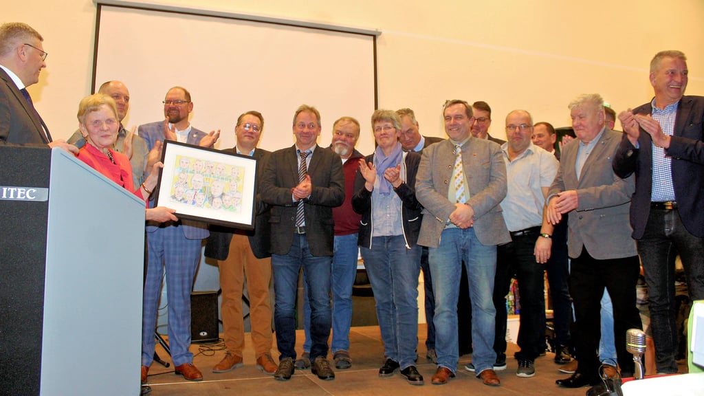 Die 14 Ortsbürgermeister und Landrat Martin Stichnoth überreichten zur Erinnerung an ihre Amtszeit mit ihnen eine Karikatur mit all ihren Konterfeis an Steffi Trittel.