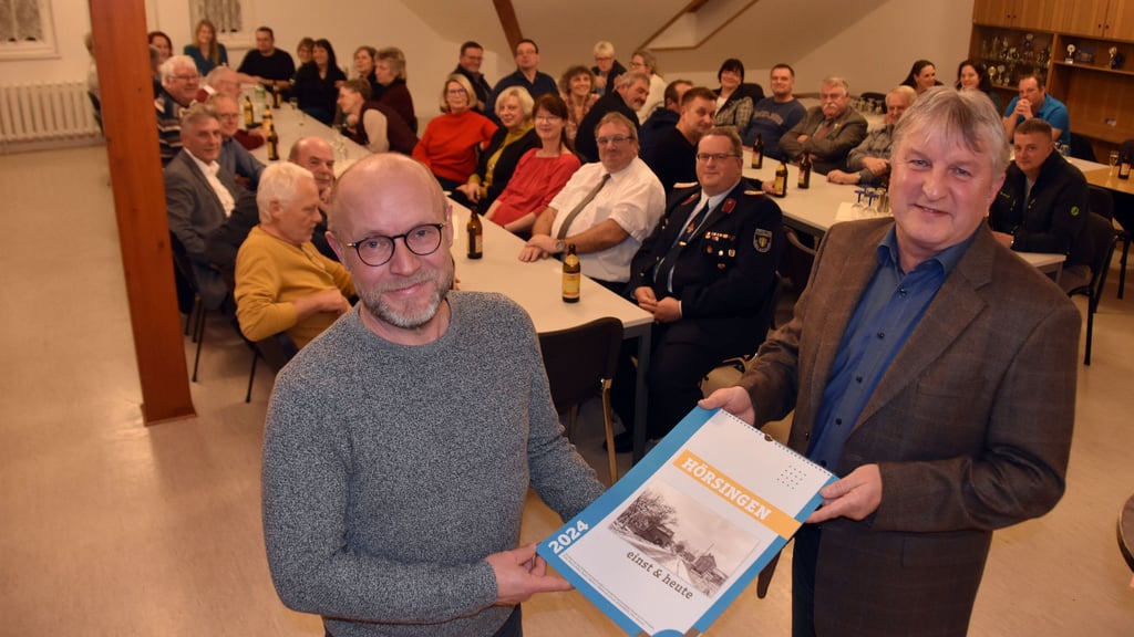 Sven Johanson (l.) überreicht beim Neujahrsempfang in Hörsingen Kalender mit historischen und aktuellen Dorfansichten von Hörsingen. Ortsbürgermeister Peter Schorlemmer verschenkt an diesem Abend einige der Kalender an besonders engagierte Bürger des Ortes.