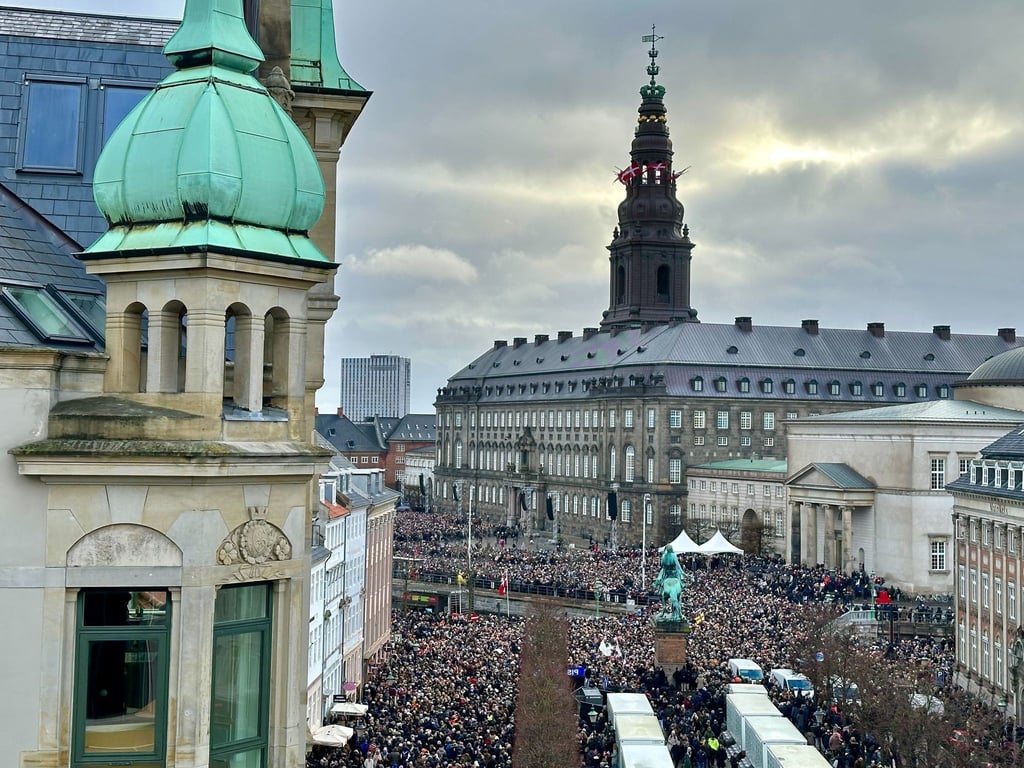 Menschen versammeln sich auf dem Platz von Schloss Christiansborg.