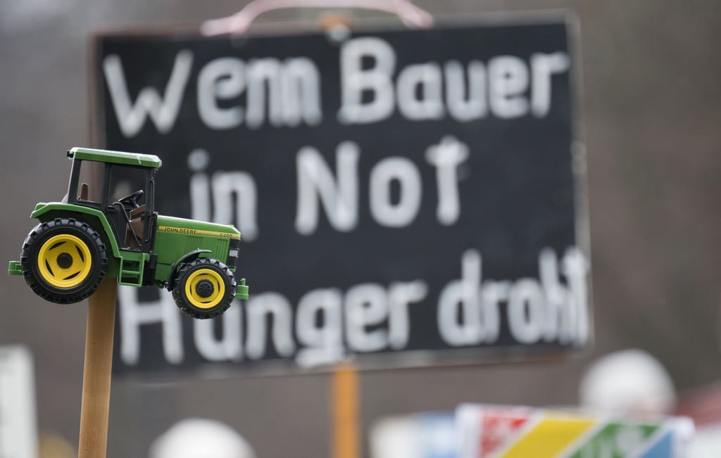 "Wenn Bauer in Not Hunger droht" steht während einer Protestdemonstration hinter einem Spielzeugtraktor.