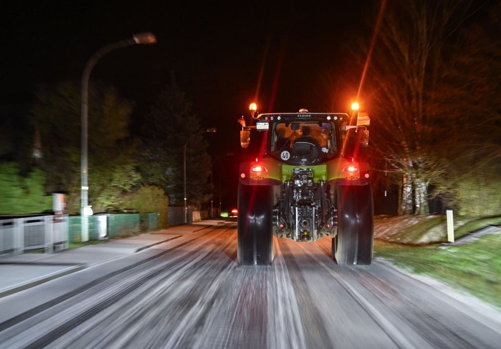 Ein Landwirt ist am frühen Morgen mit seinem Traktor unterwegs in Richtung Berlin.