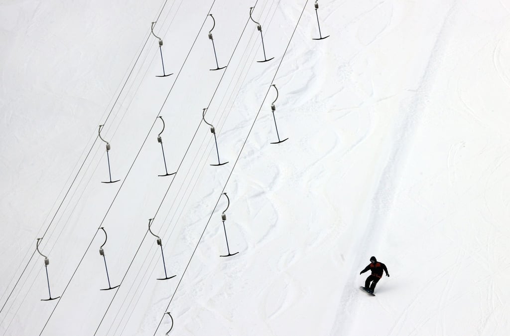 Ein Snowboarder fährt über die Piste.