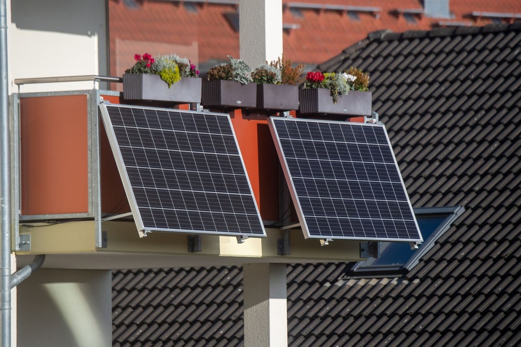 Solarmodule für ein Balkonkraftwerk hängen an einem Balkon.