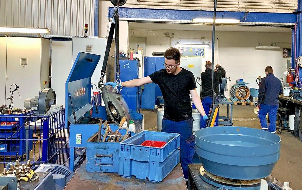 Justin Schwarz bewegt Motorteile mit Hilfe eines Kranes, dieser kann bis zu fünf Tonnen schwere Motoren heben.