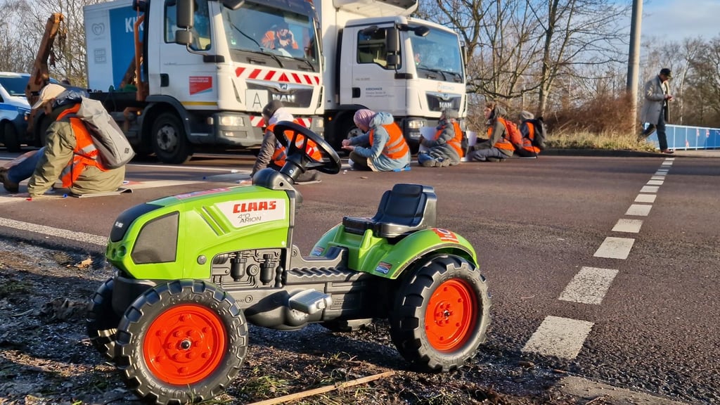 Anlehnung an Bauern-Proteste in Deutschland: Mit einem Spielzeugtraktor protestiert die Letzte Generation in Halle.