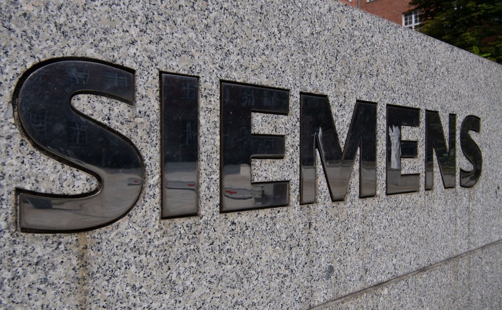 Der Schriftzug "Siemens" ist vor dem Eingang eines Gebäudes der Firma Siemens in Siemensstadt zu sehen.