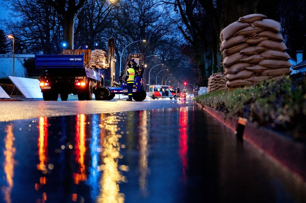 Einsatzkräfte des Technischen Hilfswerks (THW) laden zahlreiche Sandsäcke an der Sandkruger Straße ab.