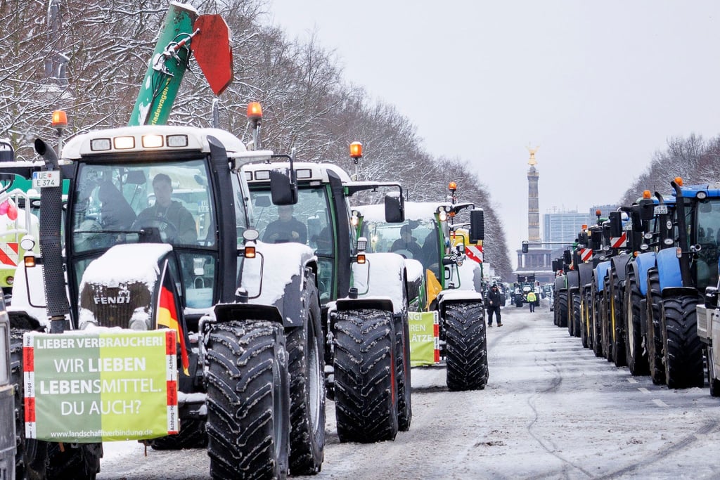 Ein Schild mit der Aufschrift „Wir lieben Lebensmittel. Du auch?“ ist an einem Traktor befestigt.