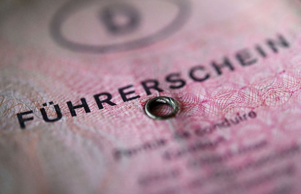 Ein rosafarbener Führerschein liegt auf einem Tisch.