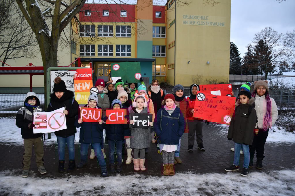 Schüler einer Magdeburger Grundschule protestieren gegen rauchende Eltern vor dem Schultor.