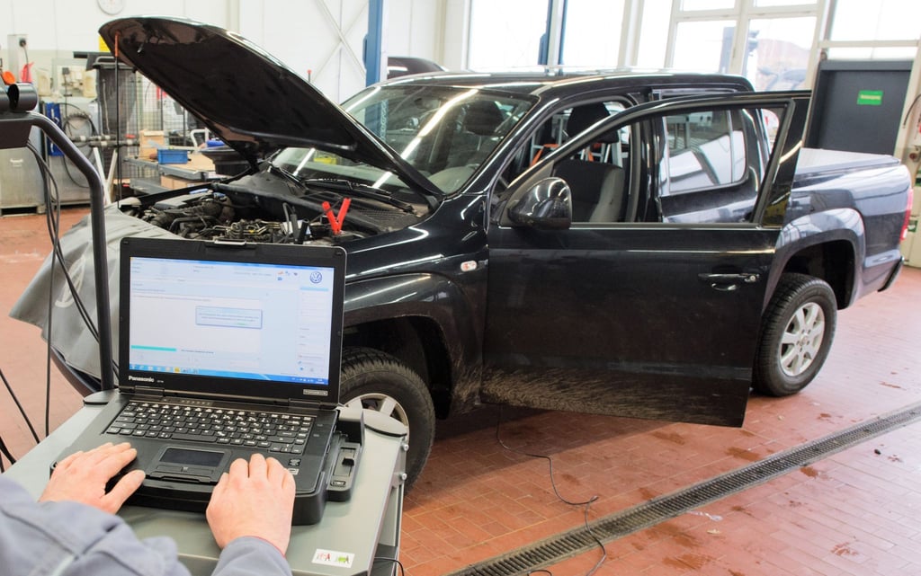 Ein Kfz-Meister lädt ein Software-Update für das Steuergerät der Motorelektronik auf einen Volkswagen Amarok.