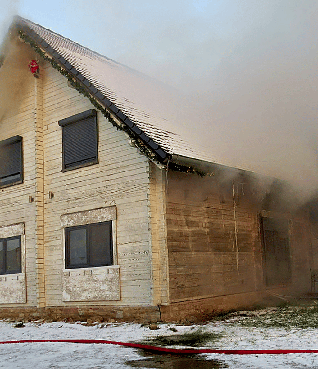 Das in Brand stehende Holzhaus.