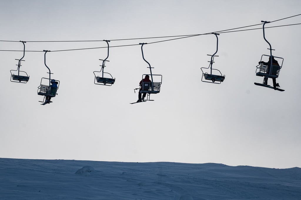 Wintersportler sitzen am Matthias-Schmidt-Berg im Harz in der Seilbahn.