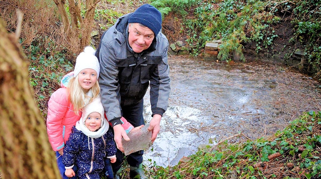 Erstmals seit mehreren Jahren führt die Schrotequelle wieder Wasser. Nach den trockenen vergangenen Jahren war sie zuletzt ganz versiegt. Fazsiniert vom Eis auf der Quelle waren auch die Enkelinnen Helena (links) und Elenor von Detlef Feldmann, in dessen Garten die Schrote entspringt.