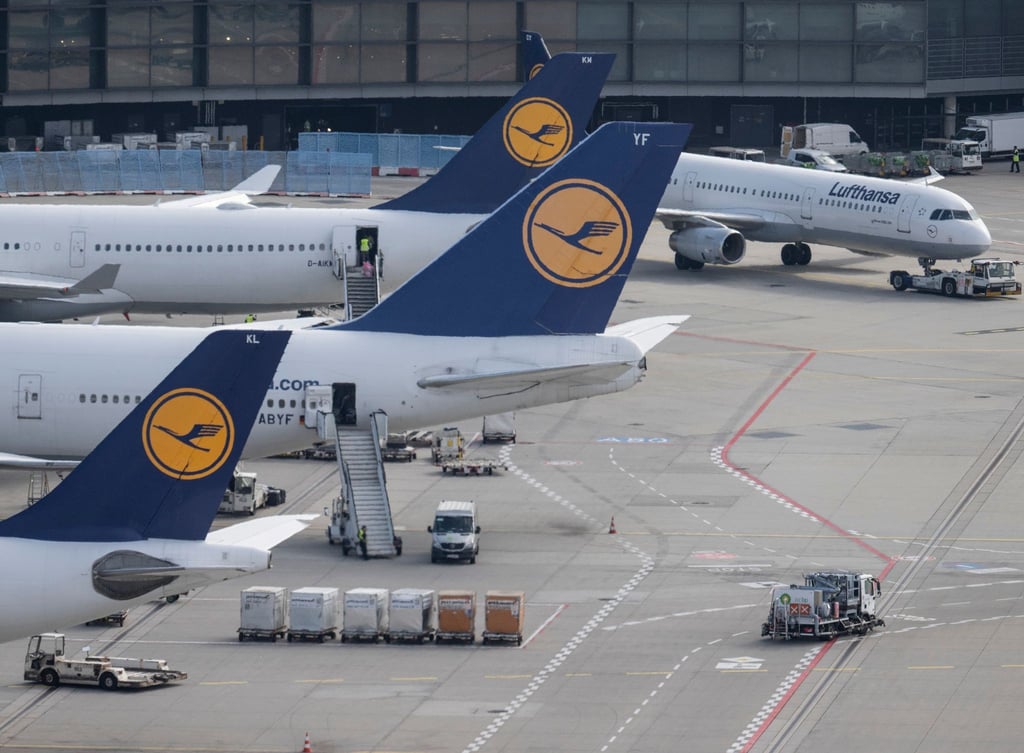 Passagierjets der Lufthansa stehen auf einem Flughafen.
