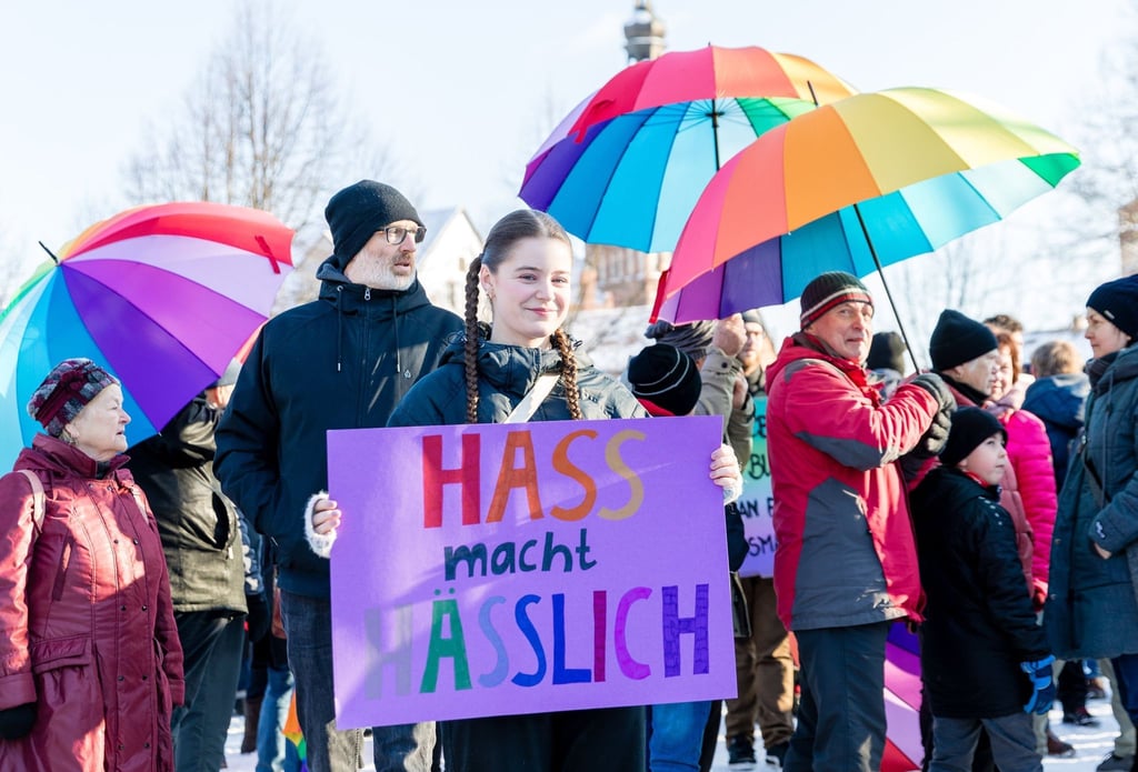 Menschen halten Schirme in Regenbogenfarben bei der Demonstration „Bunte Zukunft statt braunes Hinterland“.