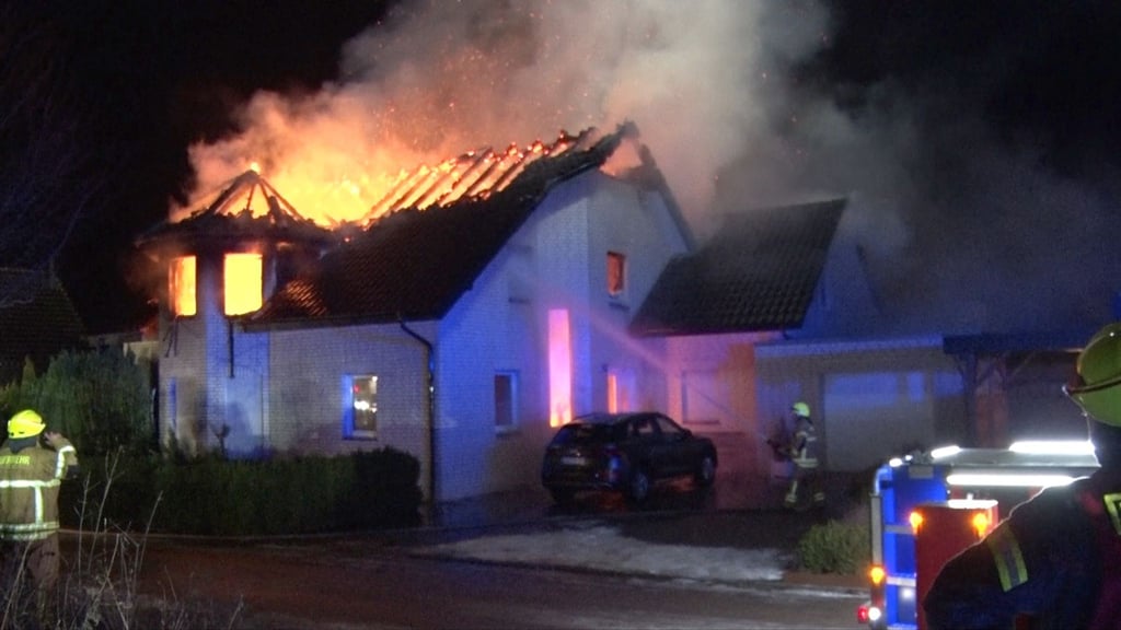 Flammen schlagen aus dem Dachstuhl des Hauses.