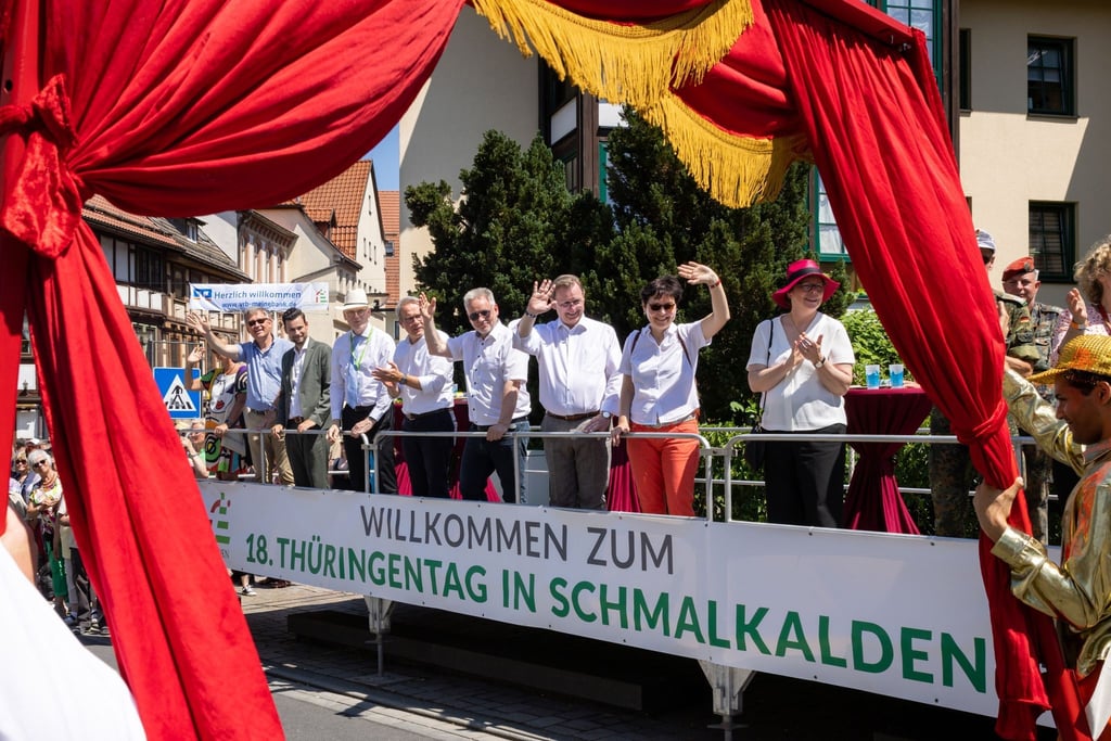 Ministerinnen und Minister winken beim Festumzug zum Abschluss des 18. Thüringentags.