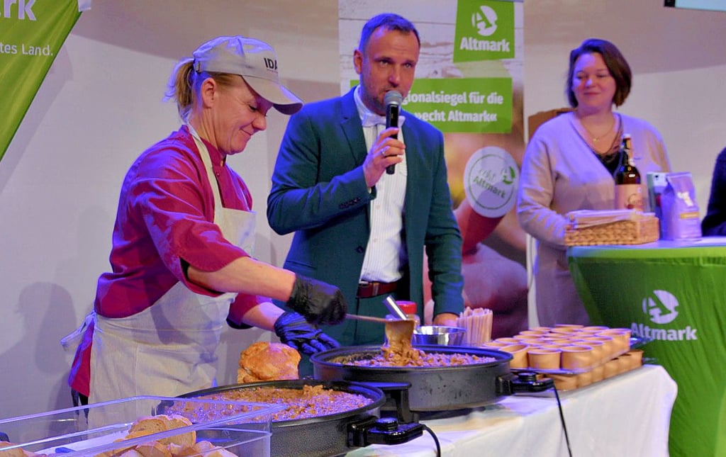 Doro Hirsing, Köchin im Integrationsdorf Arendsee, bereitete auf der Bühne „Beschwipstes Rind im Altmark-Topf“ zu. Daianira Leja (rechts), Geschäftsführerin des Integrationsdorfs, stand Moderator Stefan Timm-Zock Rede und Antwort.