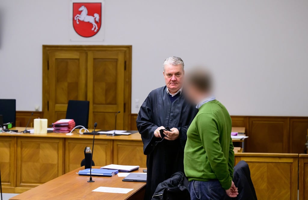 Anwalt Dirk Meinicke (l), und der Angeklagte stehen vor Prozessbeginn im Saal vom Landgericht.