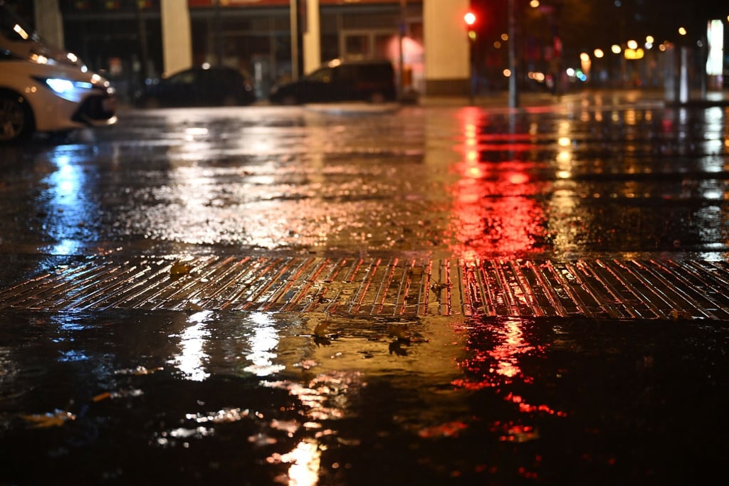 Lichter spiegeln sich auf den regennassen Straßen.