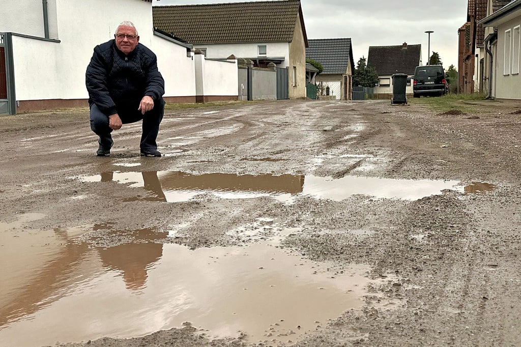 Niegripps Ortsbürgermeister Karl-Heinz Summa in der Vossenbreite, die bei Regen einer Landschaft aus Pfützen gleicht.