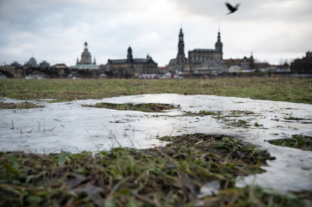 Die Elbwiesen gegenüber der historischen Dresdner Altstadtkulisse sind vom letzten Hochwasser gefroren.
