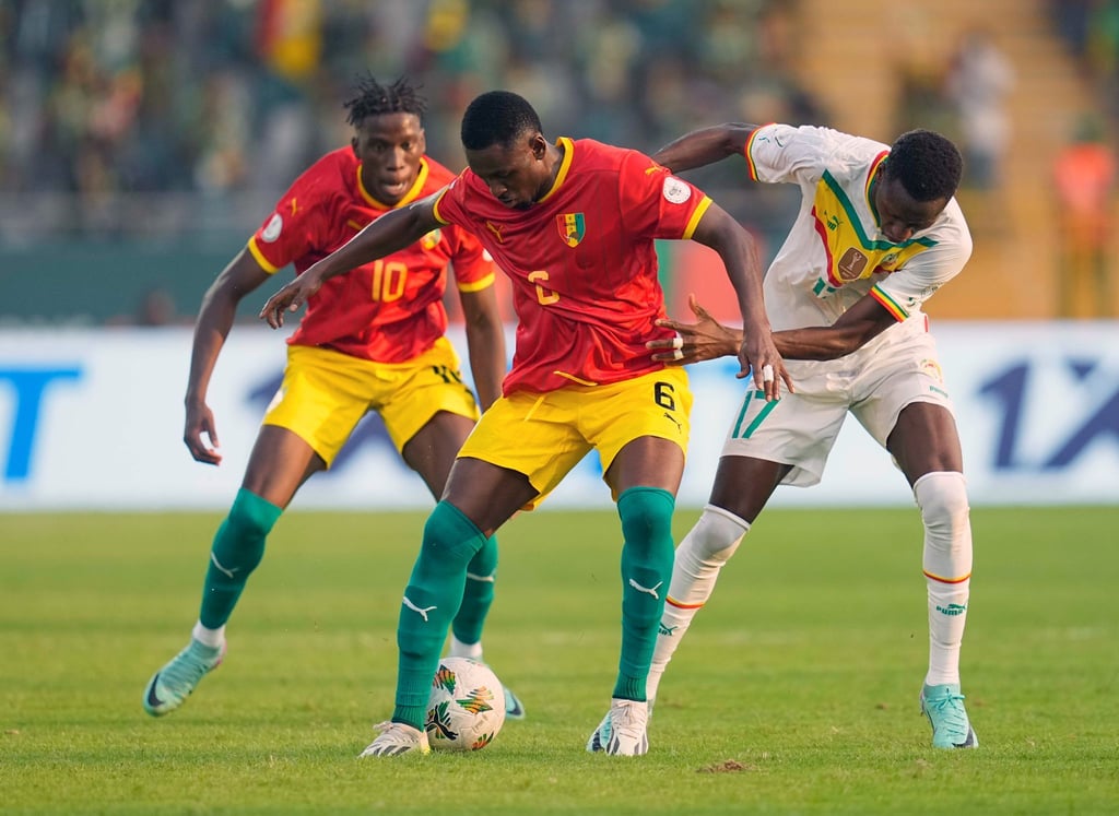 Guineas Amadou Diawara (M) versucht den Ball gegen Senegals Pape Matar Sarr (r) zu behaupten.