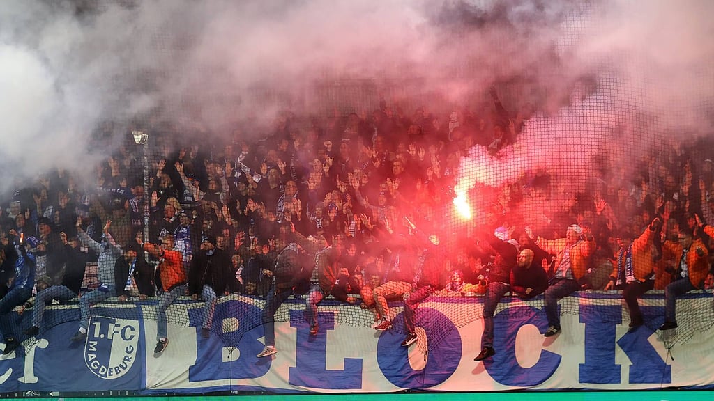 Fans des 1. FC Magdeburg mit einer bengalischen Fackel beim DFB-Pokal-Spiel in Kiel.